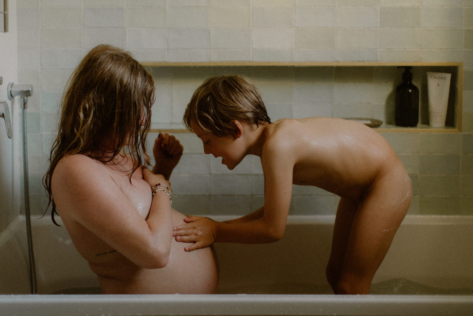 seance photo à la maison, mère enceinte et premier enfant dans la baignoire