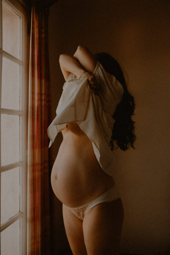 woman pregnant at home with her belly naked