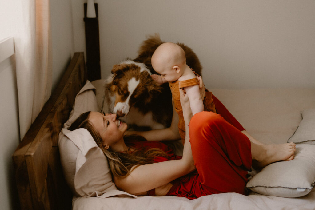 une mère et son bébé qui font des calins dans le lit lors d'une séance photo en famille